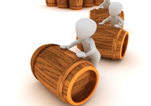 Warehouse workers rolling out barrels of business inventory purchase by securing an inventory loan.