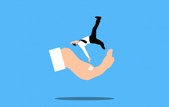 A business consultant's hand provides saves a business man from being hurt, mimicking how business insurance works.